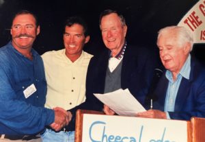 Capt. Bob Branham shakes hands with President George H.W. Bush. Andy Mill is between them and Curt Gowdy, right, is announcing them as the winners of the Islamorada Bonefish Tournament.