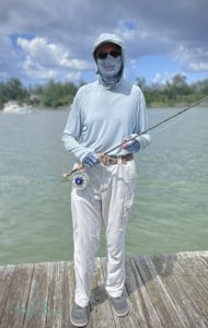 A man wearing a hat, face covering, gloves, a long-sleeved shirt and long pants to protect himself from the sun.