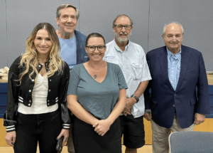 Photo of five panelists standing looking at the camera.