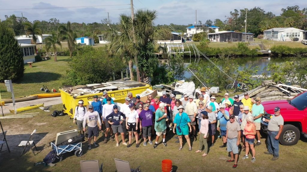 Group of volunteers stands by canal they cleaned up.