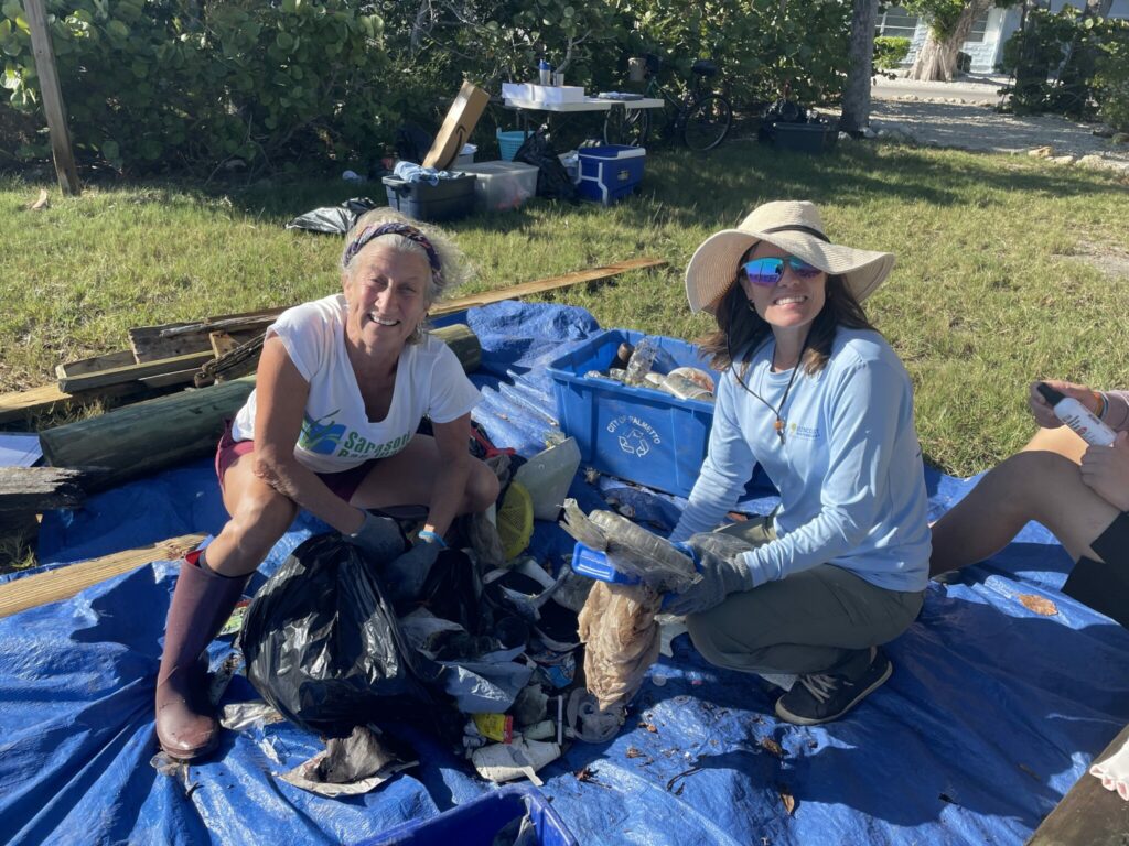 Two women show items that were cleaned up from around the Sister Keys.