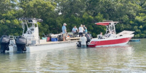 People load bags of trash on boats.